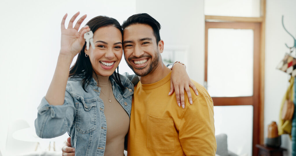 happy couple holding keys to their first home